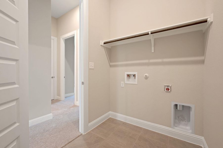 Washroom featuring gas dryer hookup, hookup for a washing machine, electric dryer hookup, light colored carpet, and light tile patterned floors
