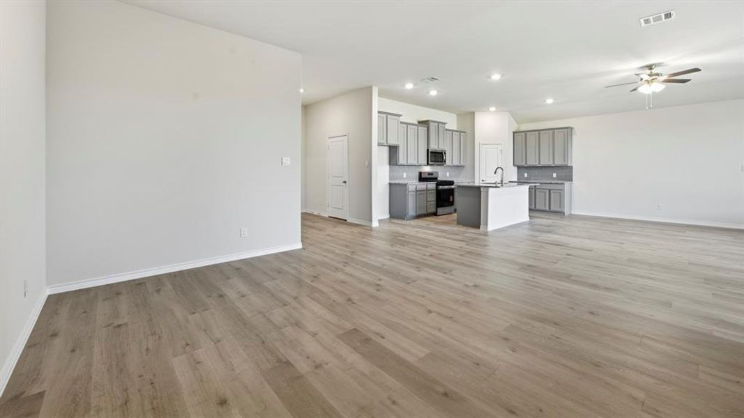 Unfurnished living room featuring ceiling fan, recessed lighting, and light wood-style floors Unfurnished living room featuring ceiling fan, recessed lighting, and light wood-style floors