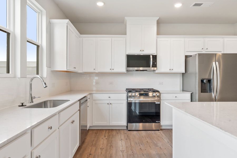 A kitchen with white cabinets.