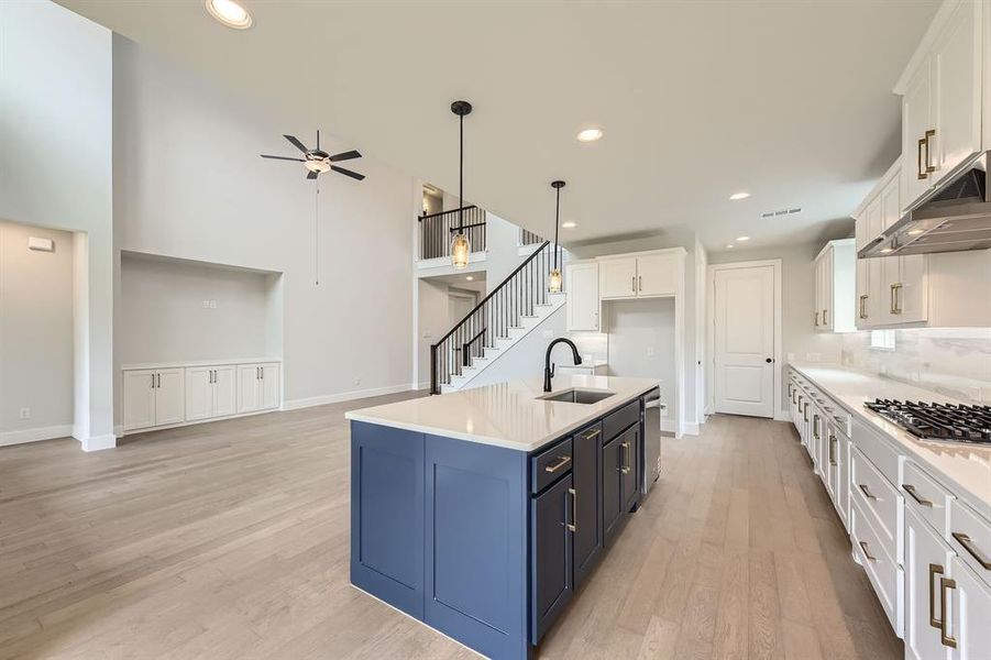 Kitchen with white cabinetry, appliances with stainless steel finishes, under cabinet range hood, a sink, and recessed lighting
