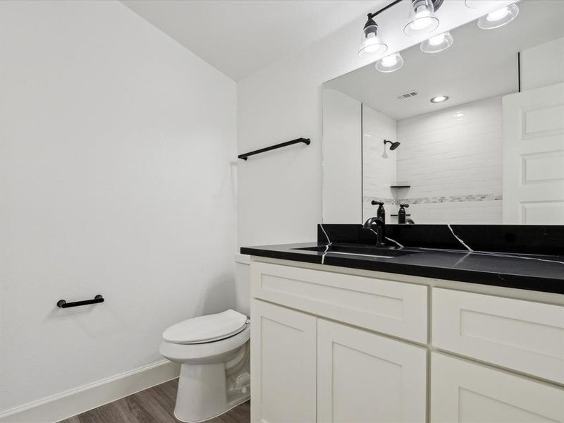 Bathroom with toilet, vanity, and hardwood / wood-style flooring