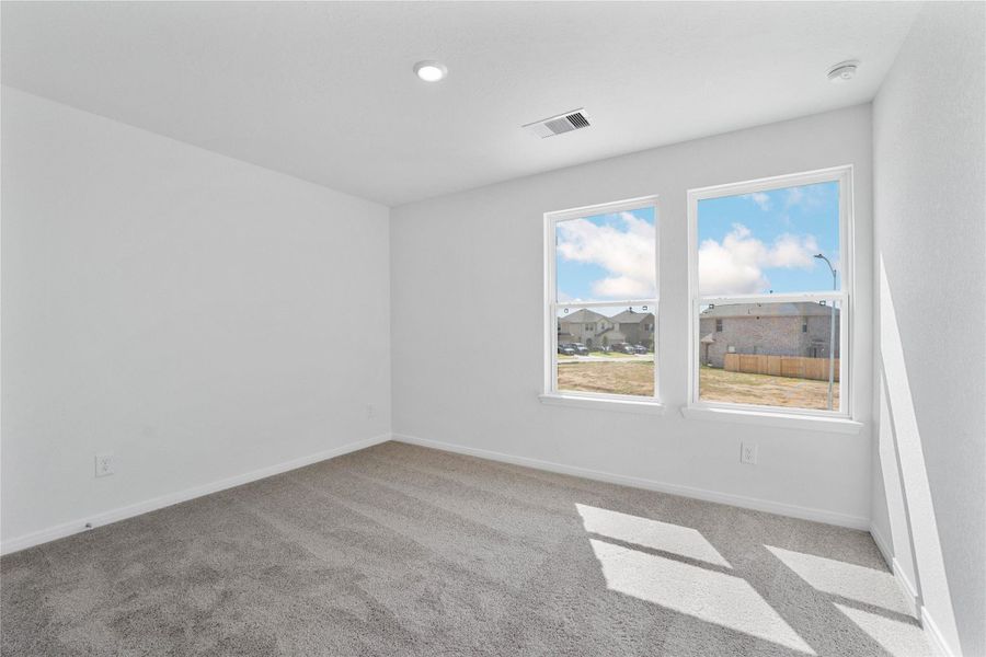 This secondary bedroom offers comfort and style with plush carpeting, neutral paint tones, recessed lighting, large windows, and a generously sized closet. This secondary bedroom offers comfort and style with plush carpeting, neutral paint tones, recessed lighting, large windows, and a generously sized closet.