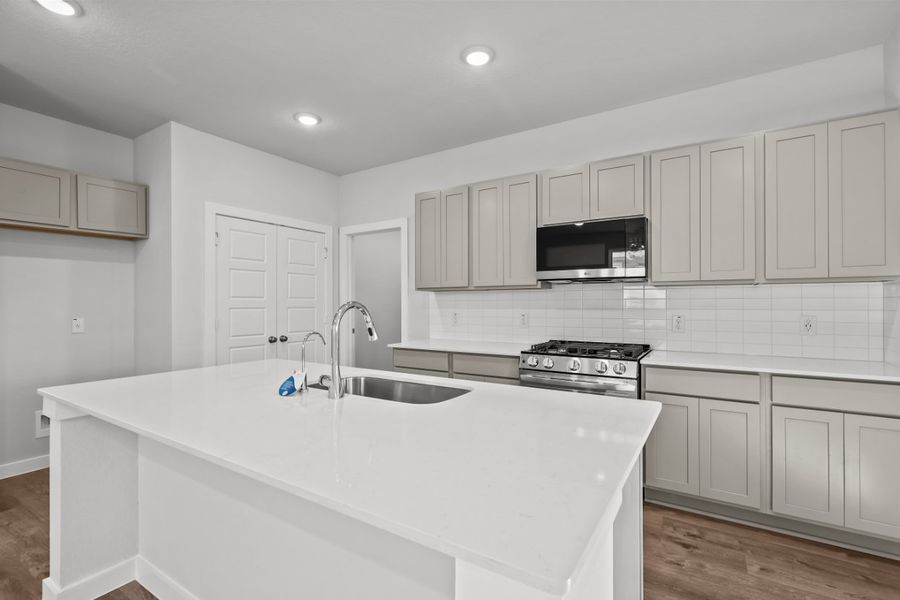 A kitchen with white cabinets.