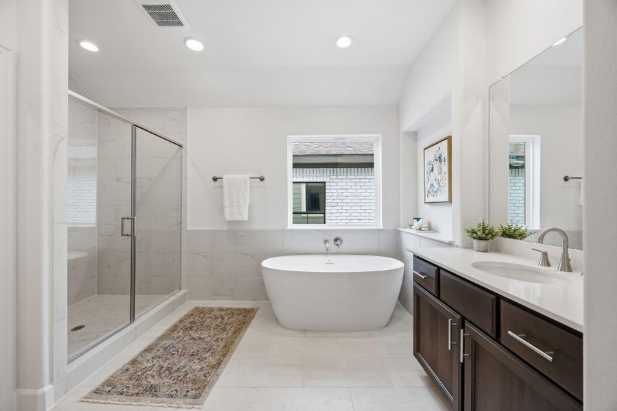 Ensuite Elegance: Step into the primary suite's ensuite bathroom, boasting abundant space and luxurious finishes, including a spa-like shower adjacent to the elegant freestanding tub.