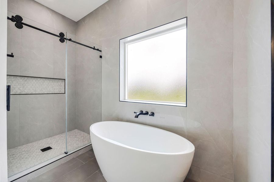 Freestanding soaking tub positioned beside large windows creates the perfect place to unwind. Freestanding soaking tub positioned beside large windows creates the perfect place to unwind.