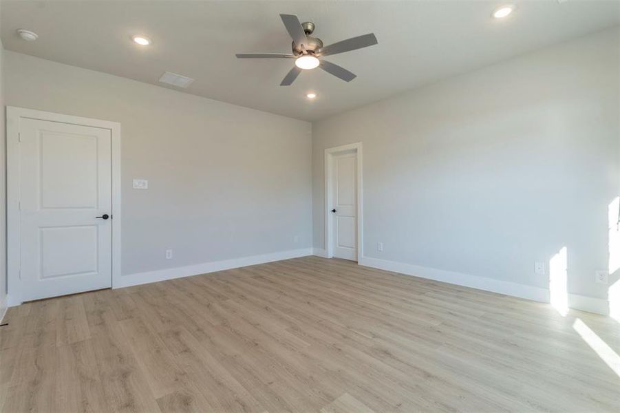 Empty room with ceiling fan, recessed lighting, and light wood finished floors
