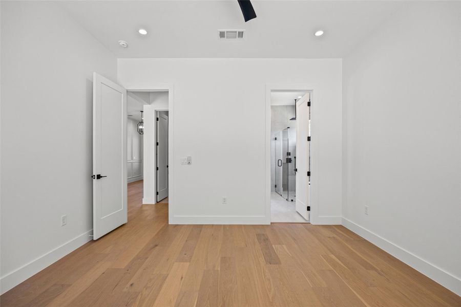 Unfurnished bedroom with light wood-style floors, a ceiling fan, recessed lighting, and ensuite bath Unfurnished bedroom with light wood-style floors, a ceiling fan, recessed lighting, and ensuite bath