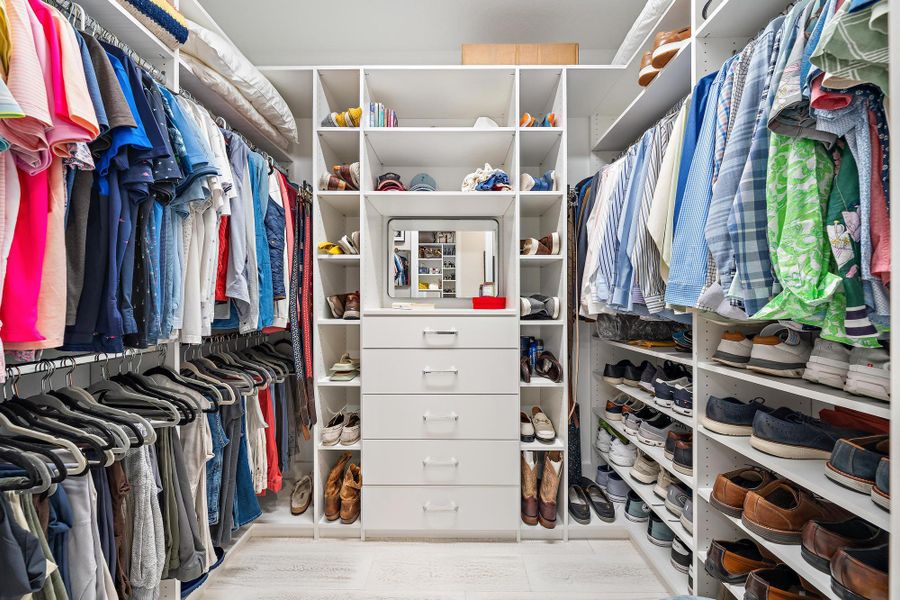 Custom closet built-ins with shelving, drawers, and chrome hardware.