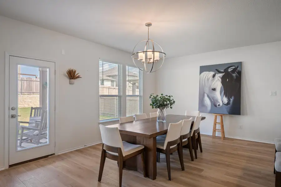 Dining room featuring light wood-style flooring and a chandelier Dining room featuring light wood-style flooring and a chandelier