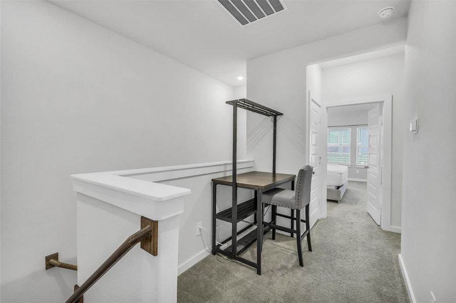 Versatile upstairs flex space perfect for a home office, reading nook, playroom, or secondary lounge area.