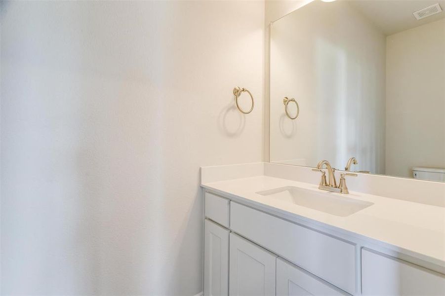 Half bathroom featuring vanity and toilet