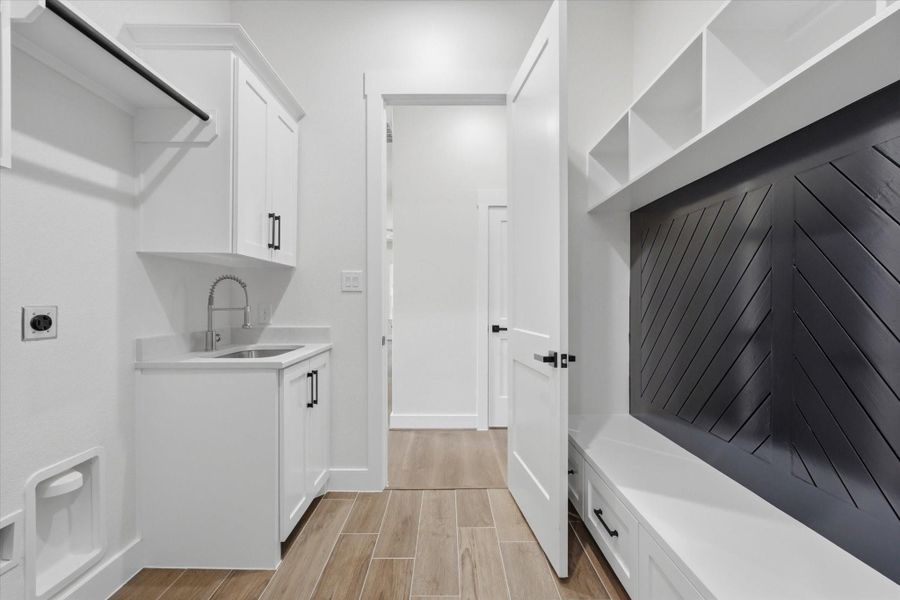 Step in from the garage to a spacious laundry room featuring a sink with extra storage and a handy mud area - perfect for hanging jackets, storing shoes, and keeping everyday essentials organized. Step in from the garage to a spacious laundry room featuring a sink with extra storage and a handy mud area - perfect for hanging jackets, storing shoes, and keeping everyday essentials organized.