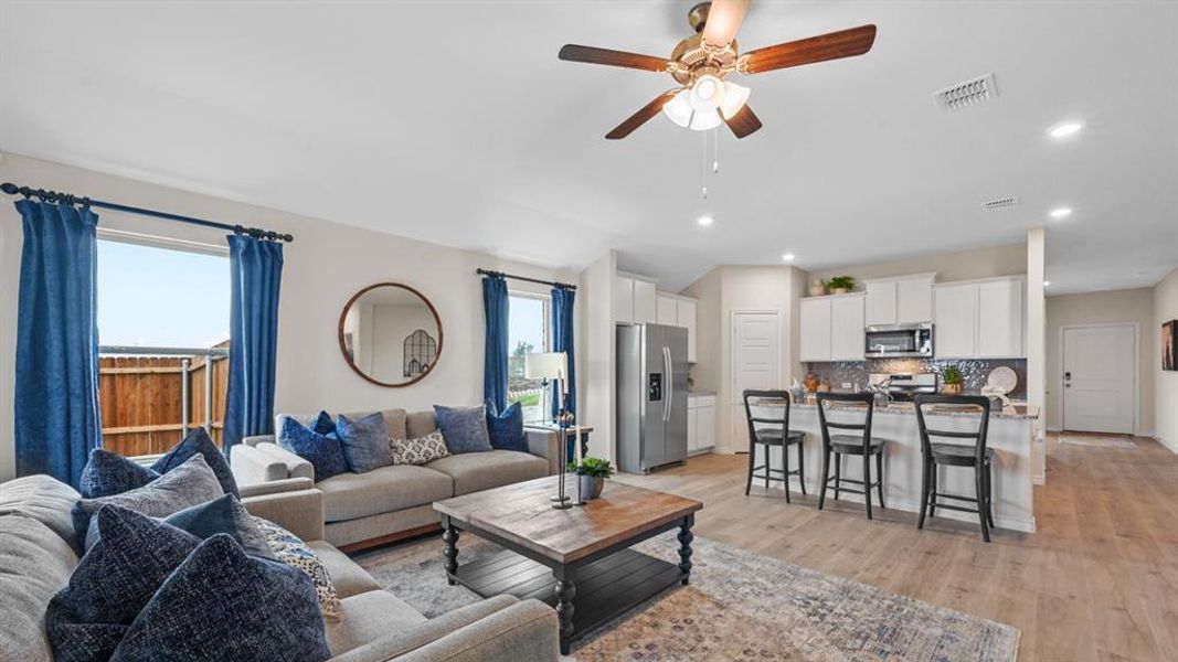 Living room with a ceiling fan, recessed lighting, and light wood finished floors Living room with a ceiling fan, recessed lighting, and light wood finished floors