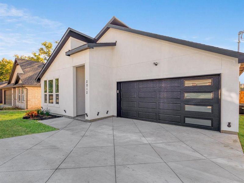 View of front of home with a front yard and a garage