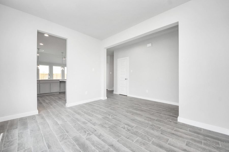 Create lasting memories with your family and friends at the dining table! This expansive dining room showcases sophisticated flooring, custom paint, and seamlessly connects to the family room and kitchen, providing an open and inviting atmosphere! Sample photo of completed home with similar floor plan. Actual colors and selections may vary.