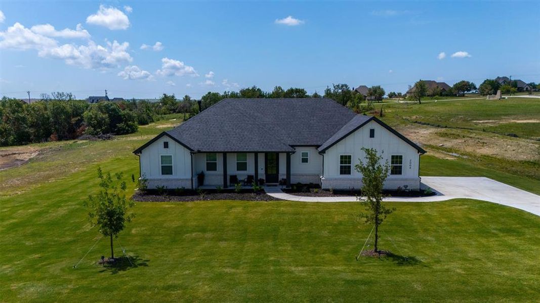 Modern farmhouse exterior with white vertical siding and dark trim