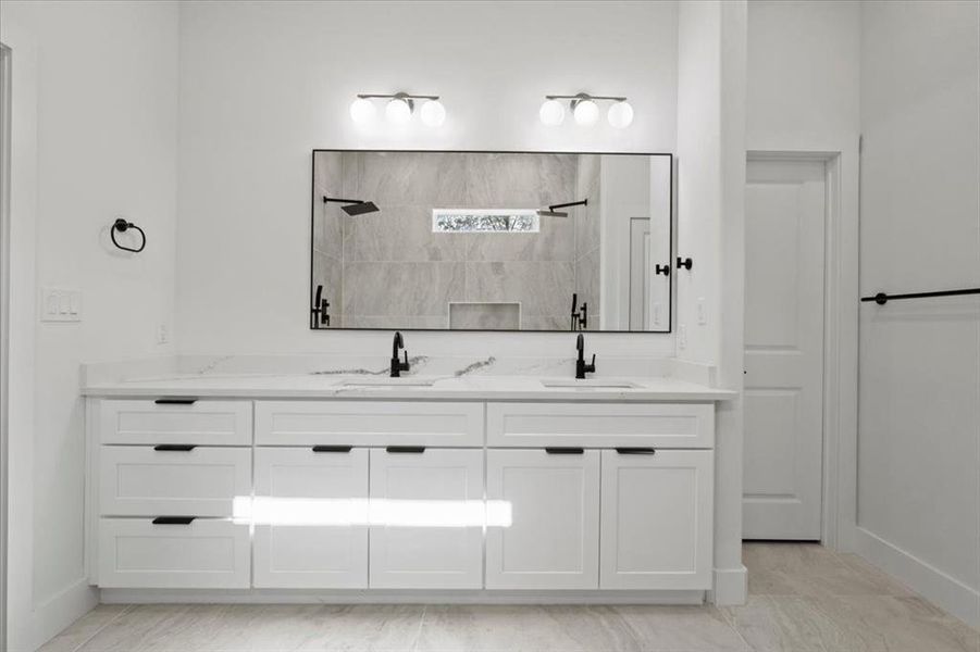 Full bath featuring double vanity and a tile shower