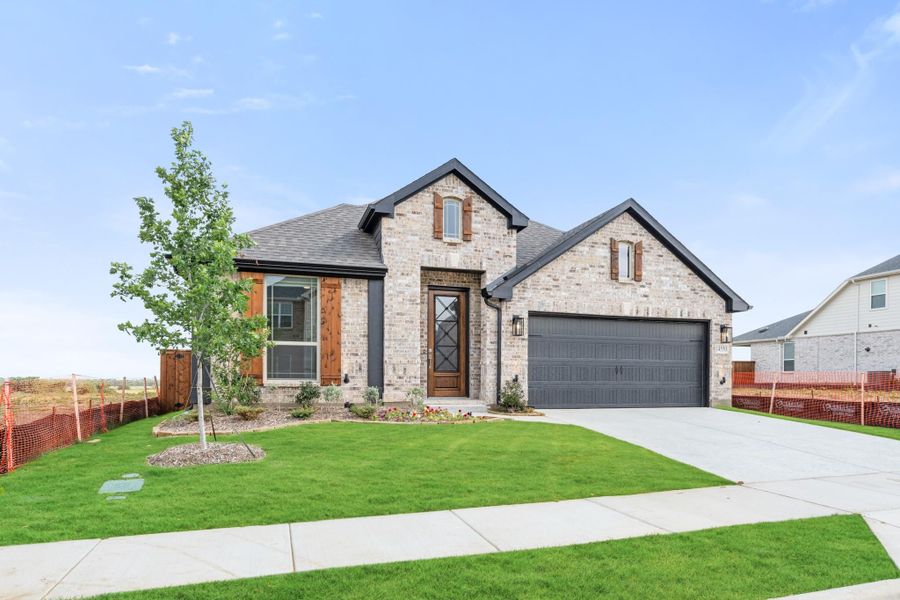 Single-story brick home with dark two-car garage, wood accents, and landscaped front yard Single-story brick home with dark two-car garage, wood accents, and landscaped front yard
