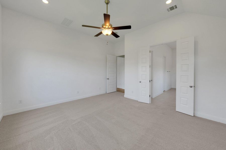 Unfurnished bedroom with light carpet, a ceiling fan, recessed lighting, and lofted ceiling