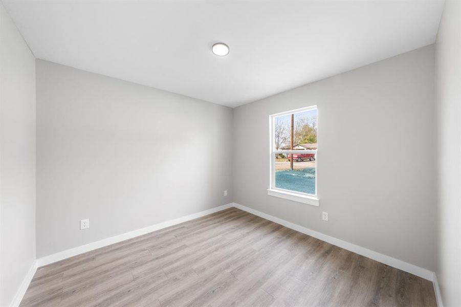 Empty room with baseboards and light wood finished floors Empty room with baseboards and light wood finished floors