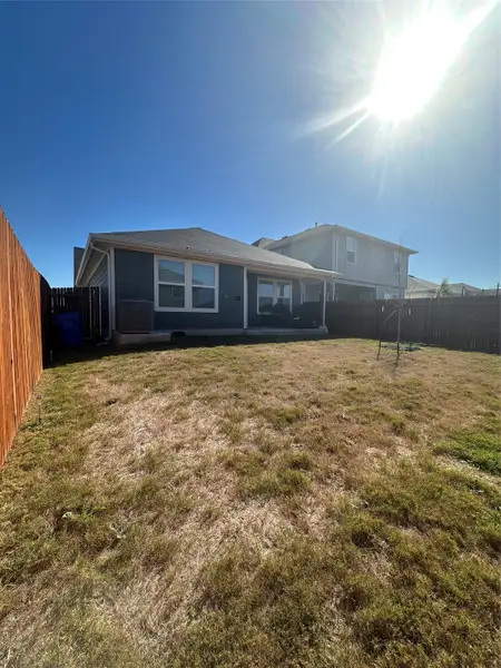 Rear view of house featuring a fenced backyard and a patio area