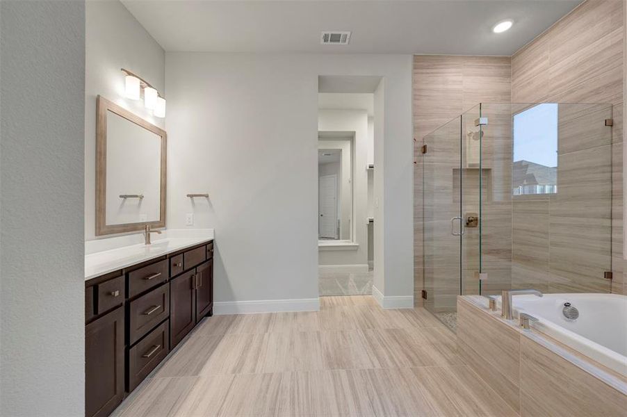 Full bathroom with vanity, a shower stall, and a garden tub