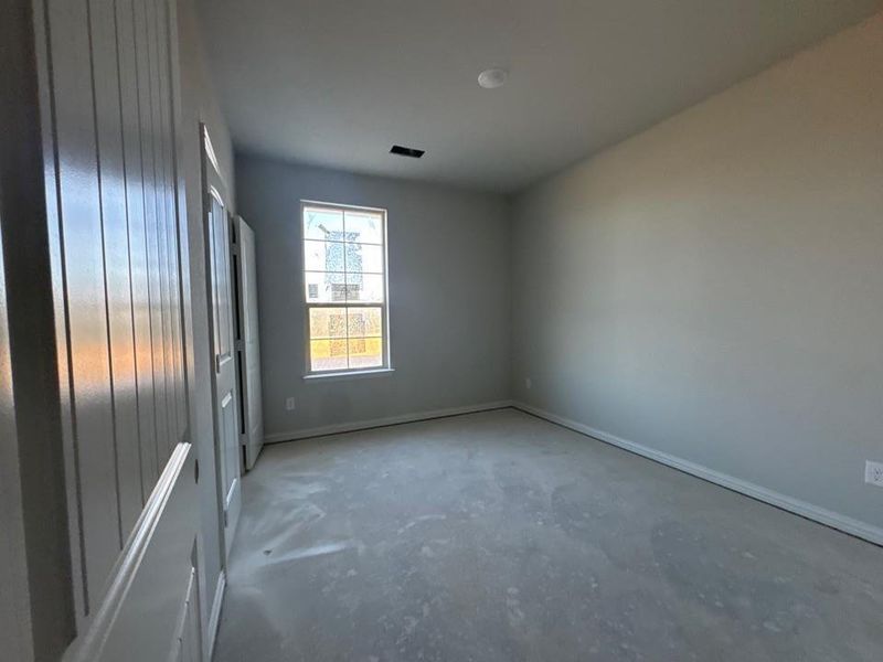 Unfurnished room with concrete floors and baseboards