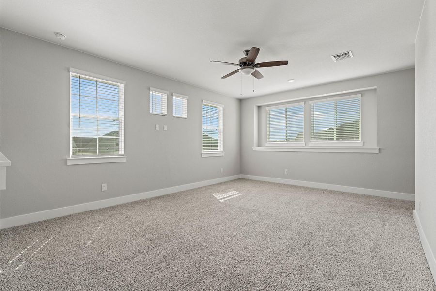 Empty room with light carpet and ceiling fan Empty room with light carpet and ceiling fan