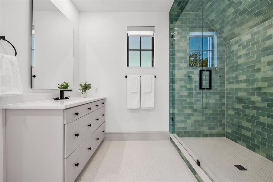 Full bathroom featuring a shower stall with designer tile