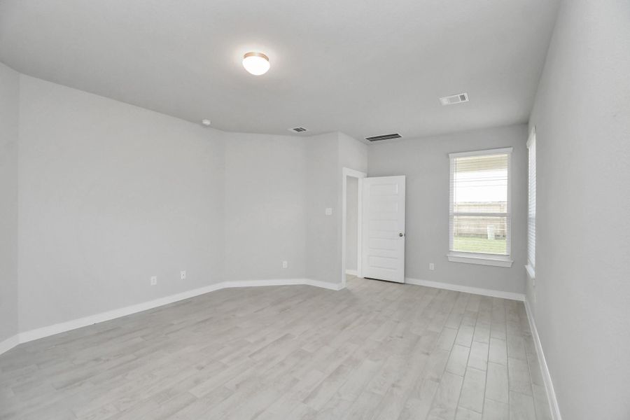 Retreat to the luxurious primary suite, your perfect escape for unwinding after a long day. Located on the first floor, this spacious room features calming paint tones, high ceilings, and large windows with privacy blinds.