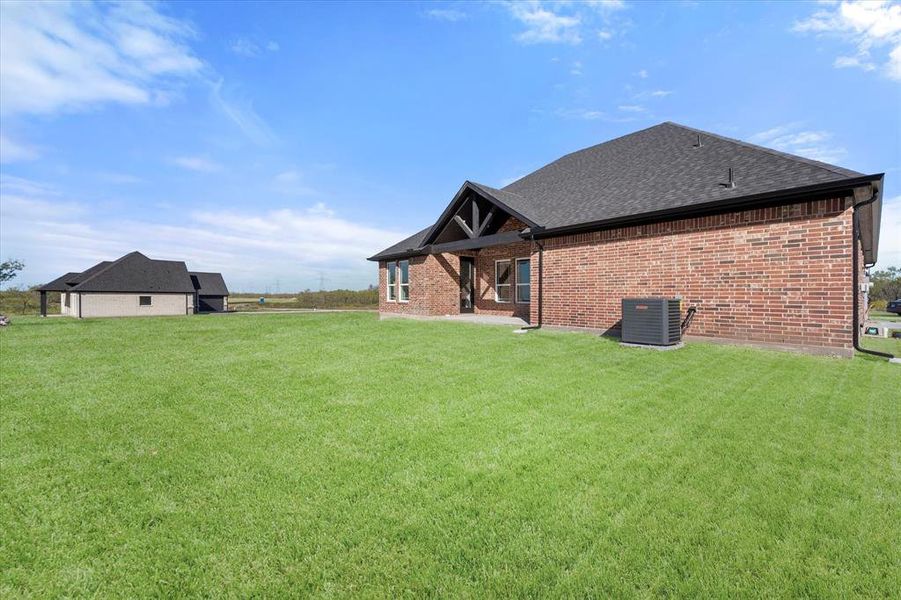 Rear view of property with a lawn and cooling unit