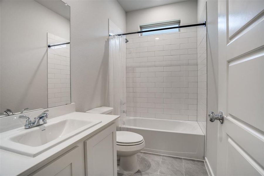 Full bathroom featuring vanity, shower / tub combo with curtain, and light tile patterned floors