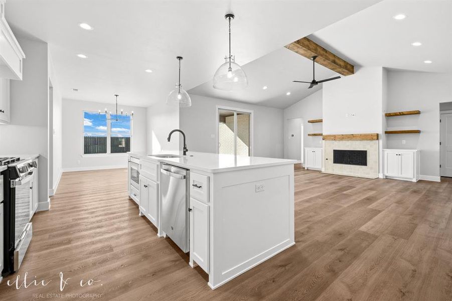 Kitchen featuring white cabinetry, light wood-type flooring, recessed lighting, and a fireplace