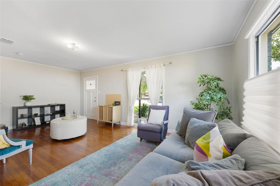 Hardwood flooring extends throughout this well-lit living area, perfect for relaxation. Hardwood flooring extends throughout this well-lit living area, perfect for relaxation.