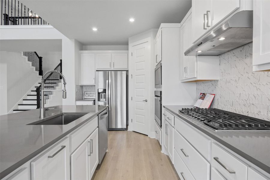 Culinary delights await in this bright kitchen, showcasing sleek appliances and abundant counter space.