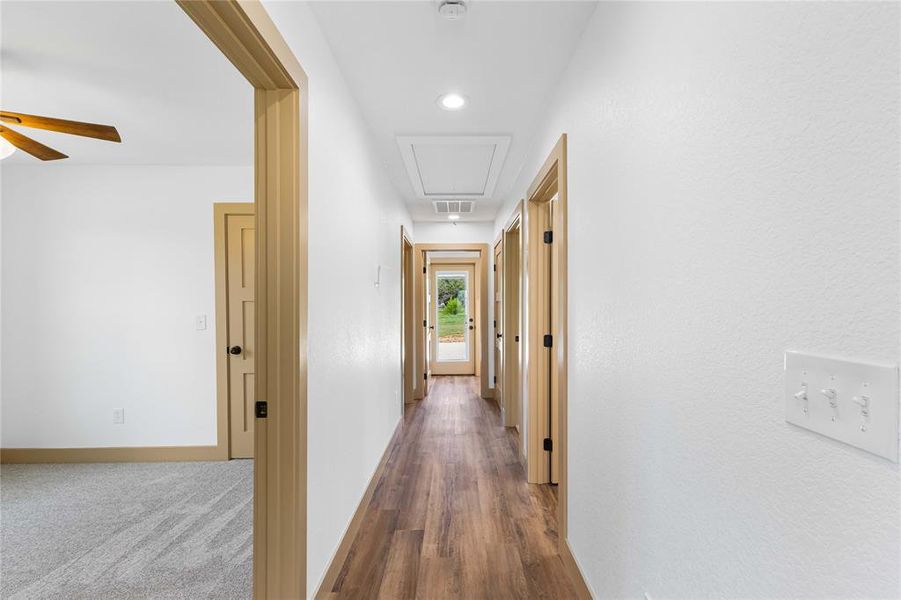Hall featuring attic access, wood finished floors, and recessed lighting