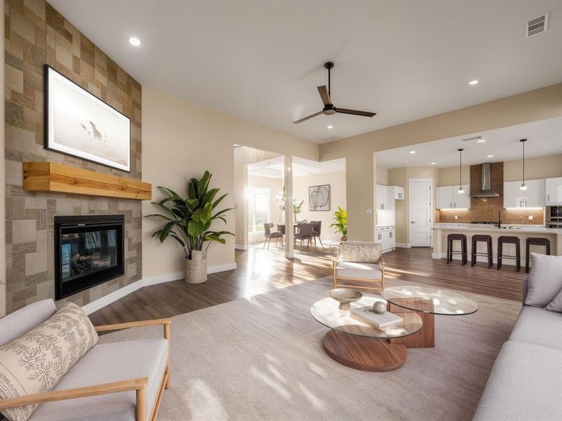 Staged Living area with dark wood finished floors, a ceiling fan, a tiled fireplace, and recessed lighting Staged Living area with dark wood finished floors, a ceiling fan, a tiled fireplace, and recessed lighting