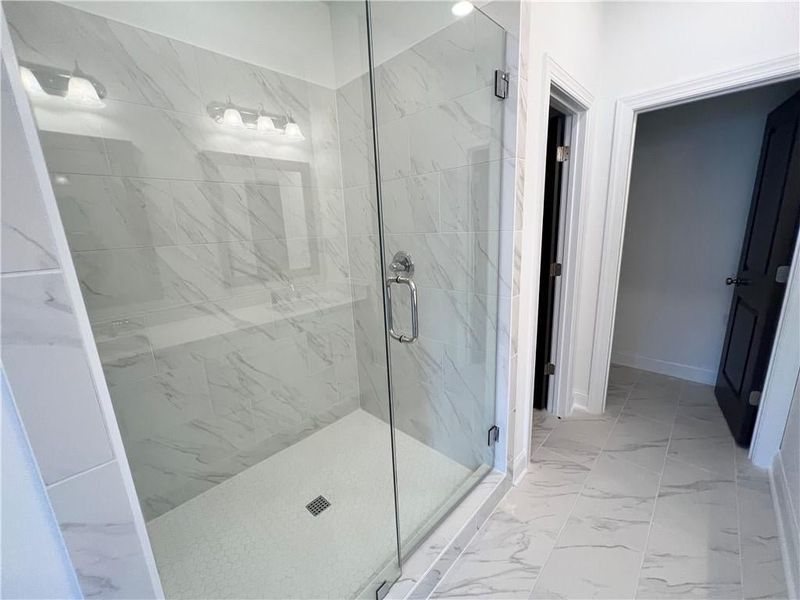 Owners Bathroom with a marble finish shower and marble finish floors
