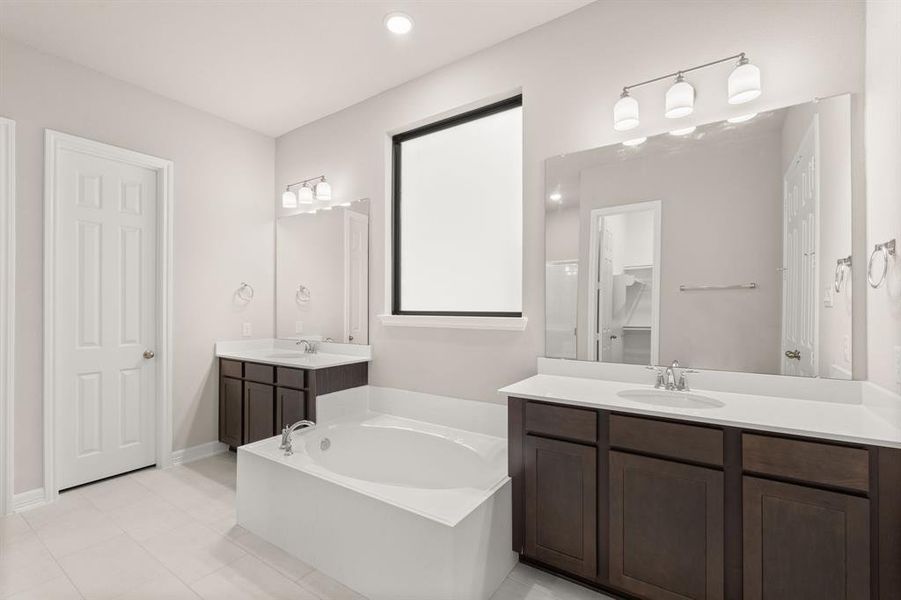 The en-suite bathroom offers a spa-like atmosphere with its elegant design, high end finishes, and tasteful lighting, creating a retreat within your own home.