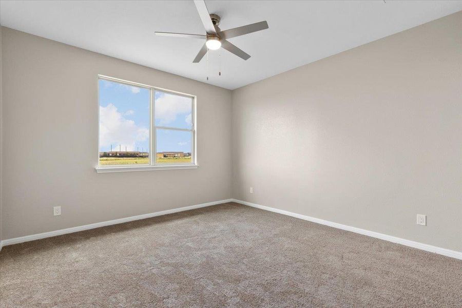 A spacious room offers ample natural light and a modern ceiling fan A spacious room offers ample natural light and a modern ceiling fan