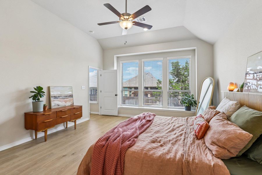 Relax in this tranquil bedroom, featuring soaring ceilings and natural light from expansive windows.
