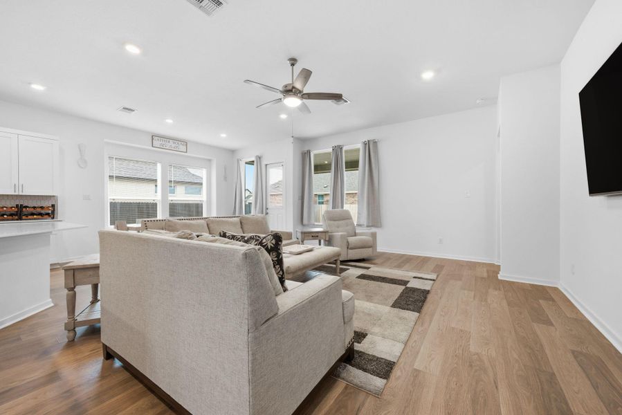 Living room featuring light wood-type flooring, ceiling fan, and recessed lighting