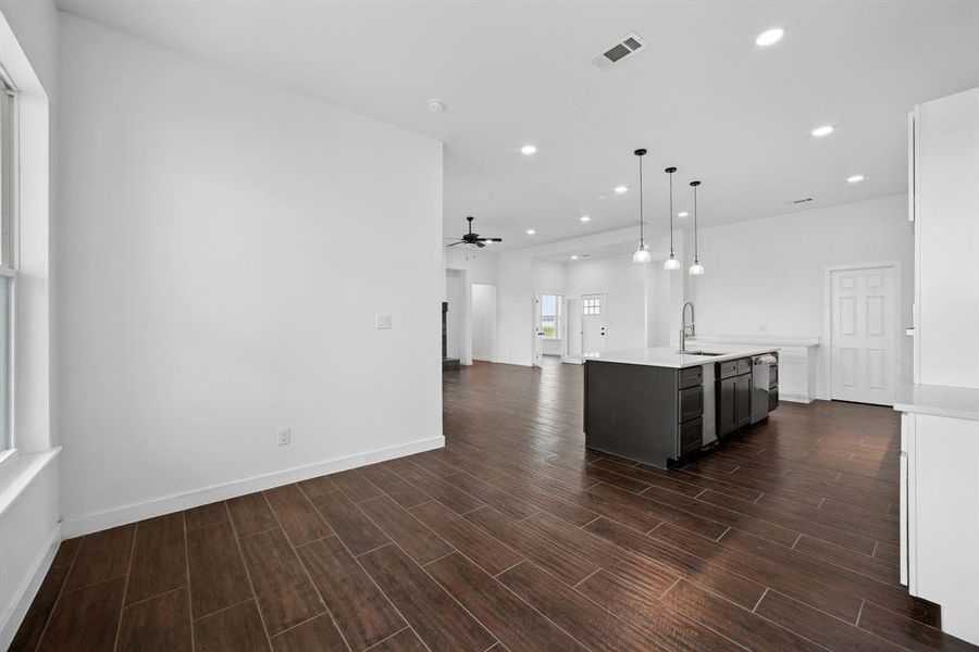 Kitchen featuring open floor plan, hanging light fixtures, recessed lighting, wood finish floors, and a ceiling fan