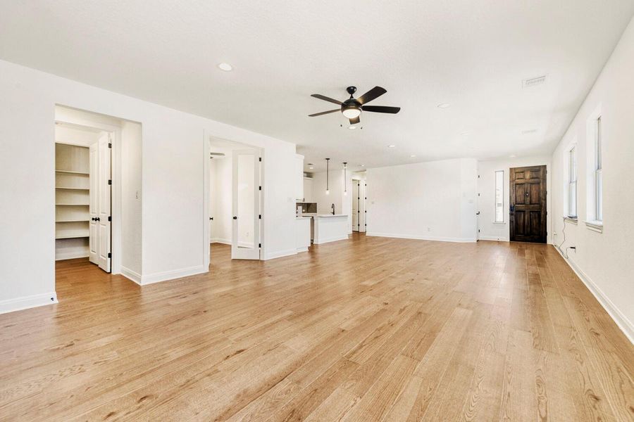 Unfurnished living room with ceiling fan, light wood-style flooring, and recessed lighting Unfurnished living room with ceiling fan, light wood-style flooring, and recessed lighting