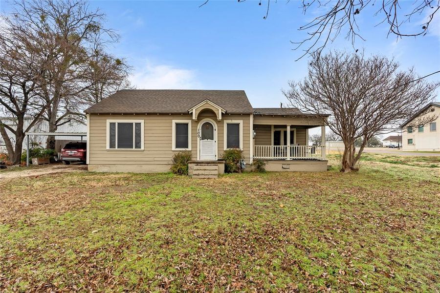 Ranch-style house featuring a porch and a front lawn