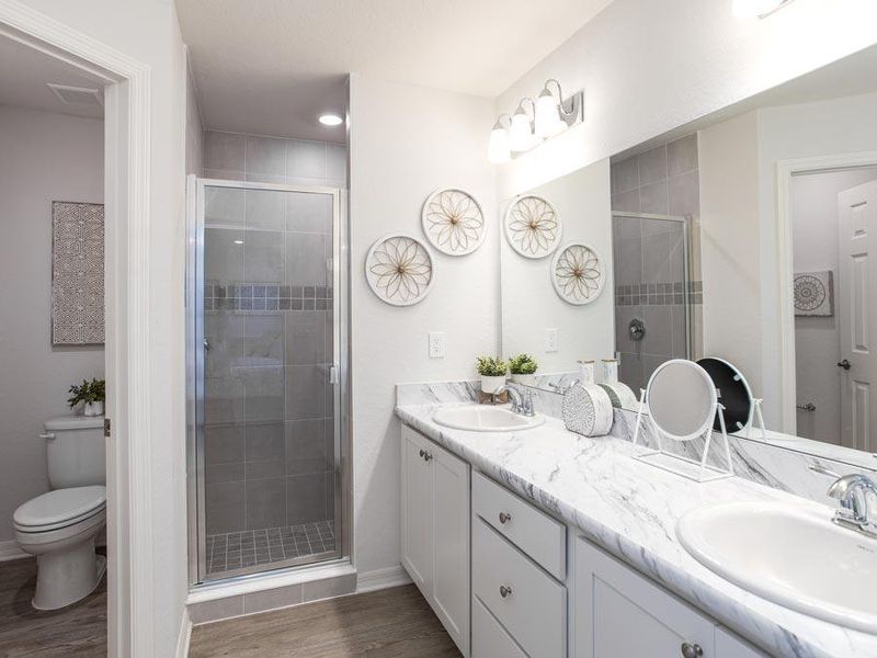 Your en-suite owner`s bath boasts dual vanities, a tiled shower, and a closeted toilet area for added privacy - Peyton home plan by Highland Homes