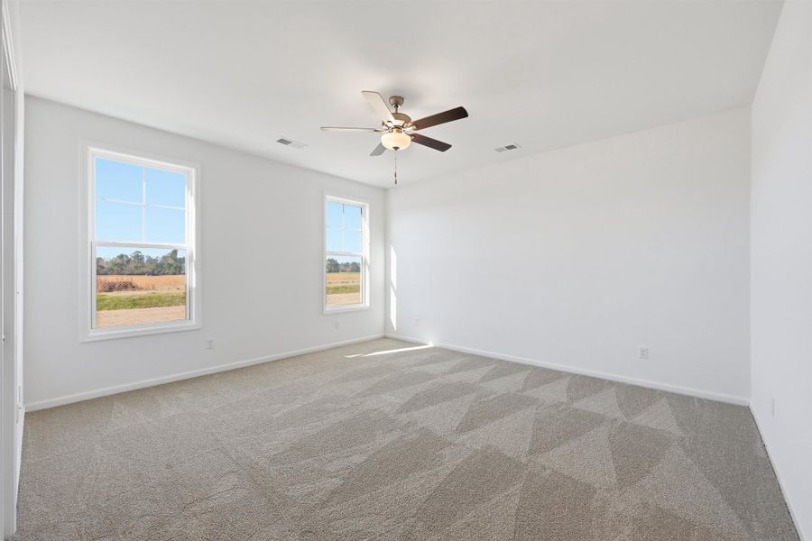 Spare room featuring light carpet and ceiling fan Spare room featuring light carpet and ceiling fan