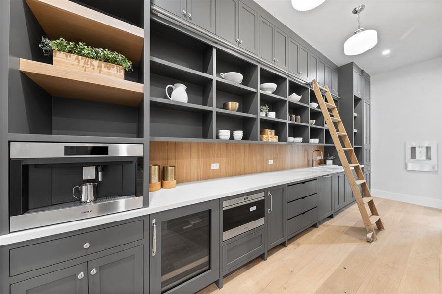 Your private butler's pantry includes floor-to-ceiling cabinetry, a microwave, a dishwasher, and a sink.