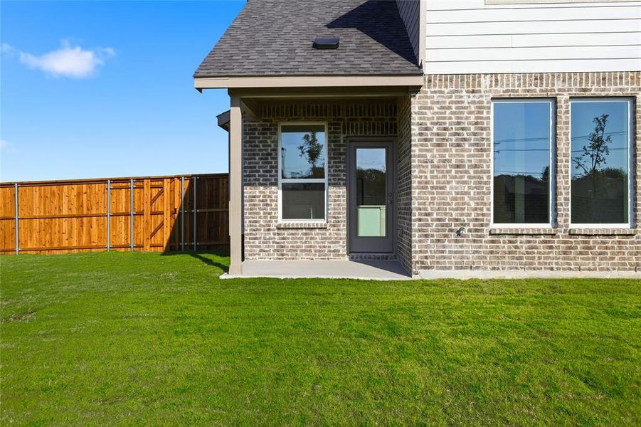 Entrance to property featuring brick siding and a shingled roof