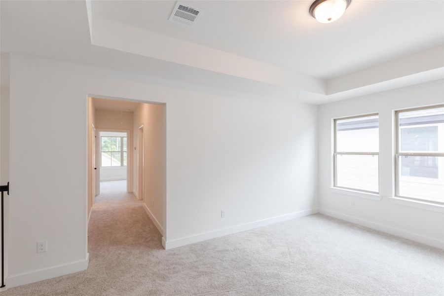 Hallway leading to the 2 bedrooms and shared bath with dual vanities